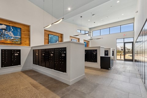 A modern office lobby with a reception desk and a large painting on the wall.