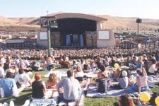 a large crowd of people sitting in front of a stage