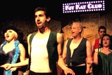 a group of men and women singing on a stage