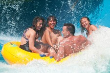 a group of people riding a wave on a yellow raft