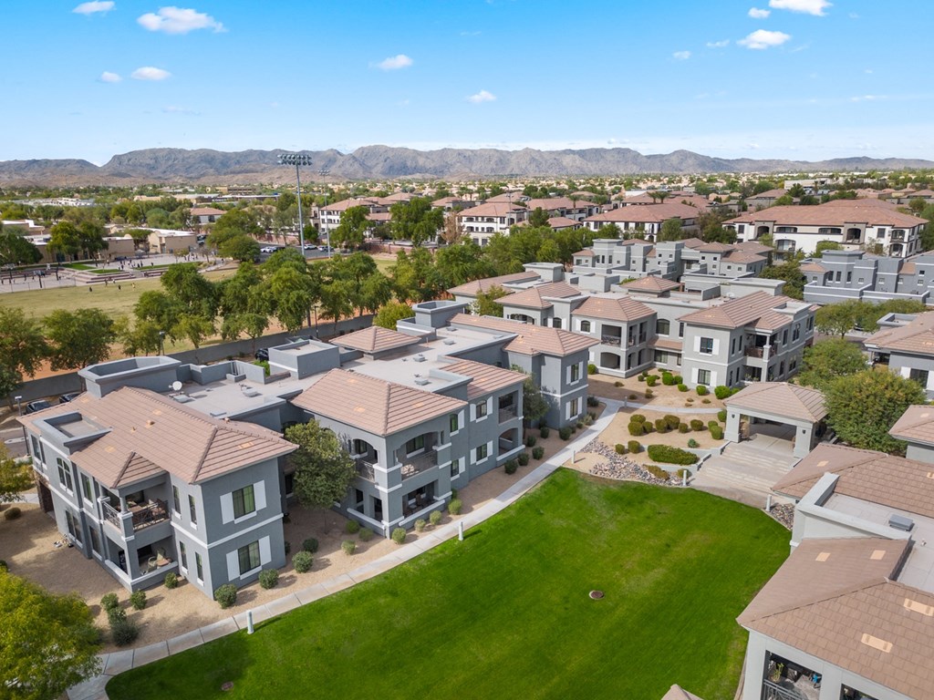 an aerial view of a neighborhood of houses with green grass and trees