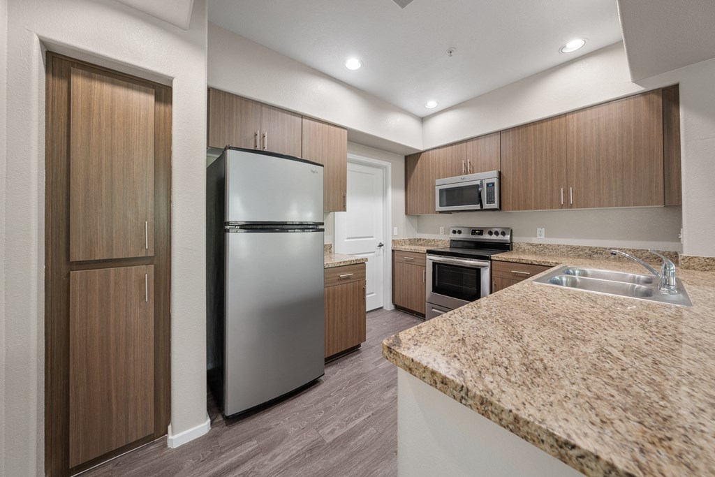 a kitchen with granite counter tops and stainless steel appliances