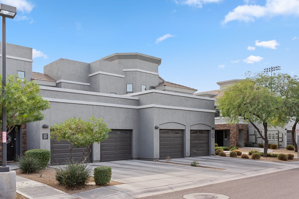 a gray house with two garage doors and a driveway