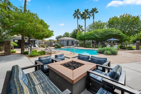 a patio with a table and chairs and a swimming pool