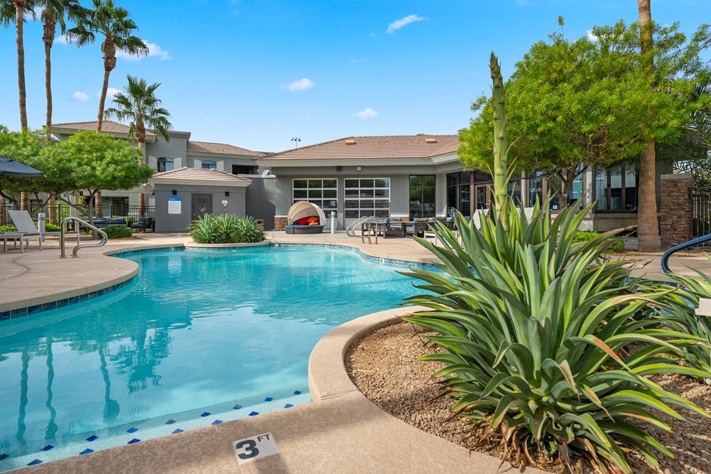 a large swimming pool with a house in the background