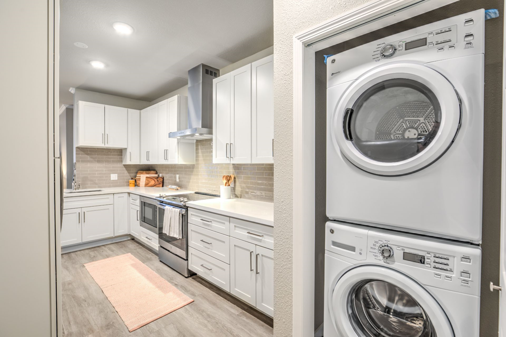 a white kitchen with a washing machine and a washer and dryer