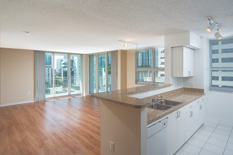 A kitchen with white cabinets and a wooden floor.