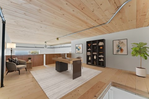 A modern living room with a wooden ceiling and a grey sofa.