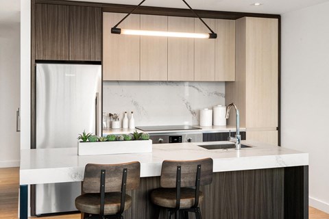 a kitchen with a marble counter top and wooden cabinets