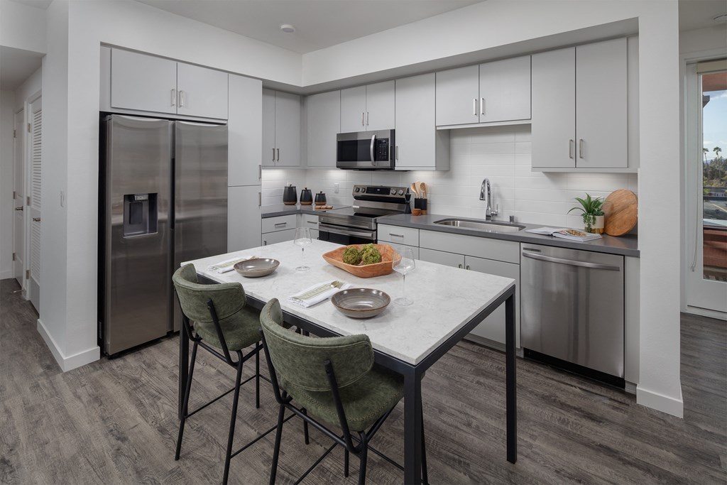 a kitchen with white cabinets and stainless steel appliances