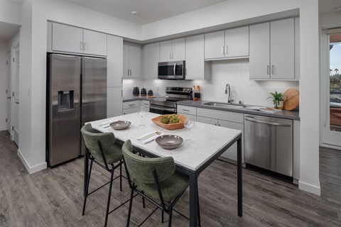 a kitchen with white cabinets and stainless steel appliances