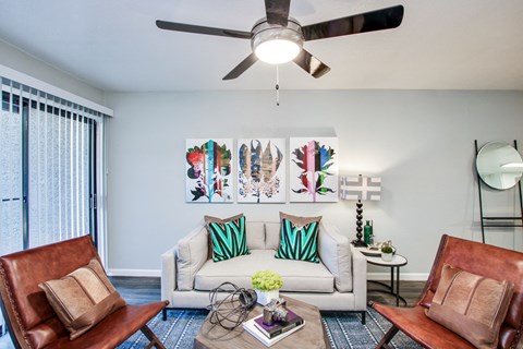 a living room with a ceiling fan and a sliding glass doorat The Julia, Mesa