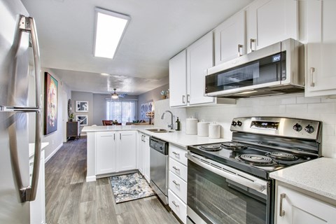 a kitchen with white cabinets and stainless steel appliances a kitchen with white cabinets and stainless steel appliancesat The Julia, Arizona