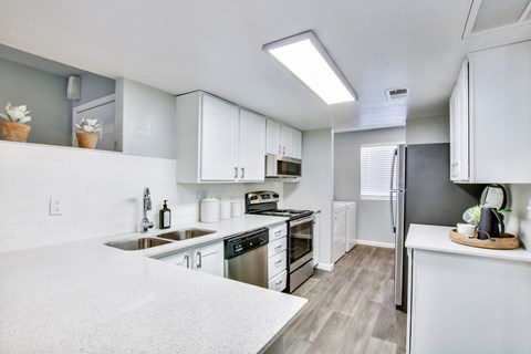 a kitchen with white cabinets and stainless steel appliancesat The Julia, Mesa, AZ 85210