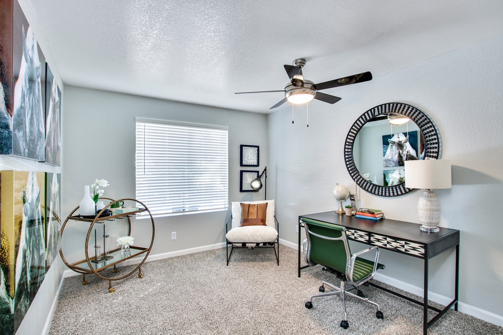 a desk with a chair and a mirror in a room with a window and a ceiling fanat The Julia, Mesa, 85210