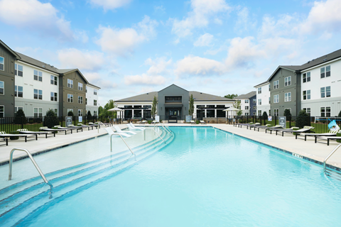 A large swimming pool in front of apartment buildings.