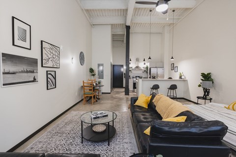 A living room with a black couch and a coffee table.