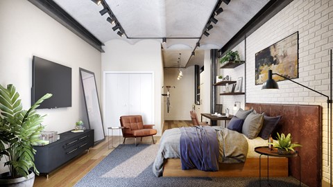 A bedroom with a bed, chair, and potted plant.