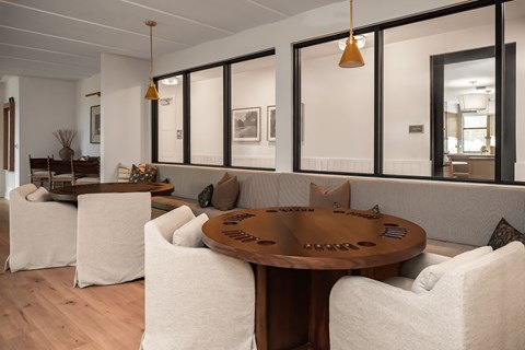 A modern living room with a wooden table and white chairs.