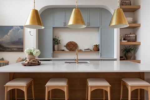 A kitchen with a white countertop and blue cabinets.