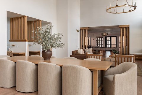 A dining room with a large table and chairs.