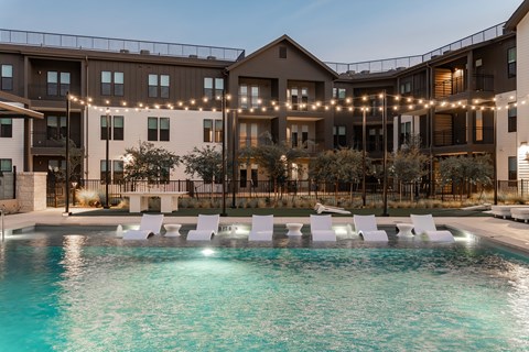 A large building with a pool in front of it.