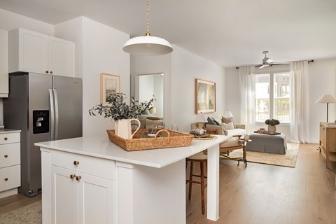 A kitchen with white cabinets and a black refrigerator.
