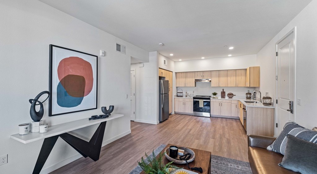 A modern living room with a large abstract painting on the wall.