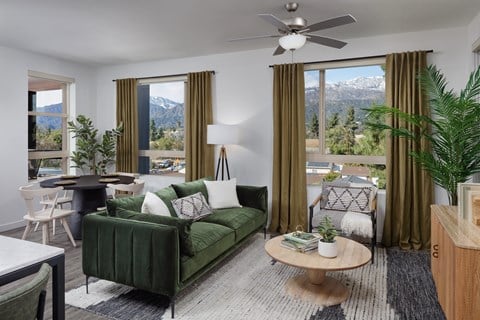 a living room with a green couch and a view of the mountains