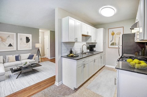 A modern kitchen with white cabinets and a black countertop.