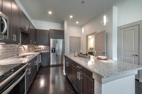 a large kitchen with stainless steel appliances and granite counter tops