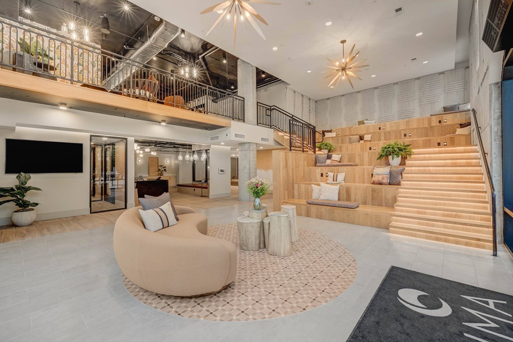 A modern interior with a staircase, a sofa, and a TV.