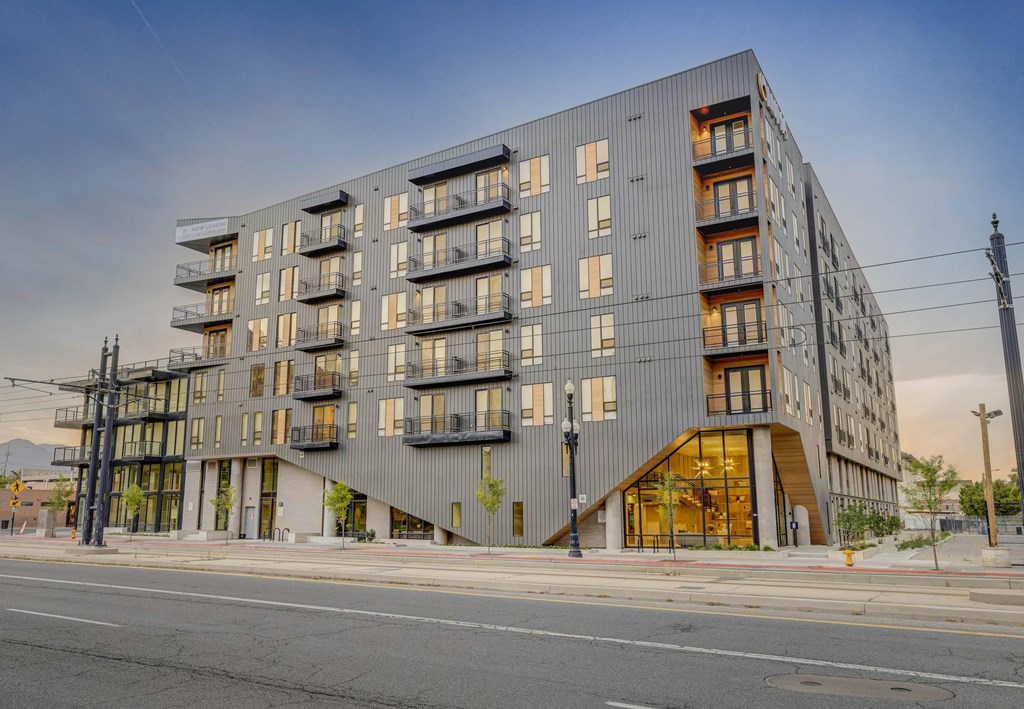 A modern apartment building with balconies and a mix of wood and metal finishes.