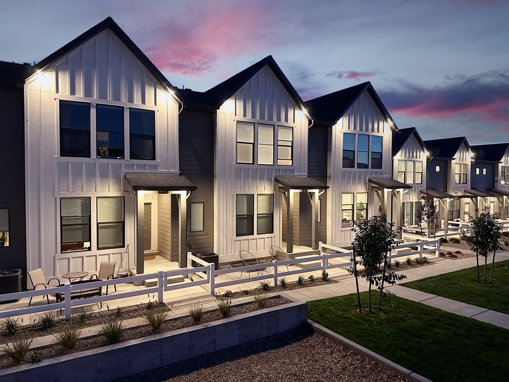 a row of houses with a sunset in the background