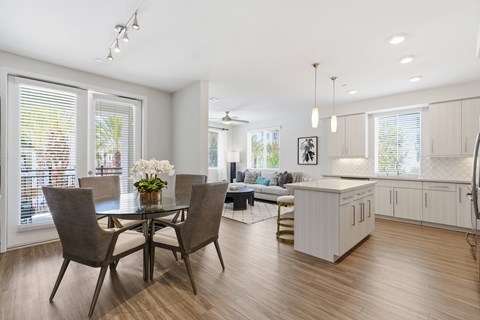 A modern dining room with a glass table and chairs.