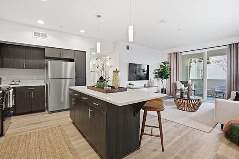 A modern kitchen with dark wood cabinets and a white island.