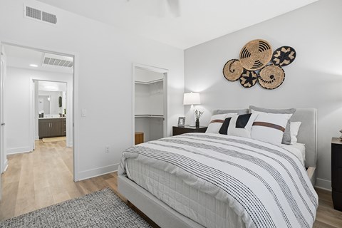 A bedroom with a large bed and a mirror on the wall.