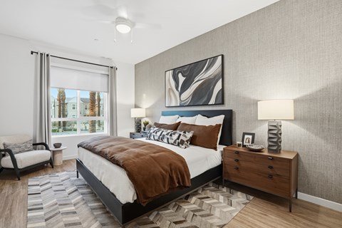 A bedroom with a large bed, a nightstand, and a painting on the wall.