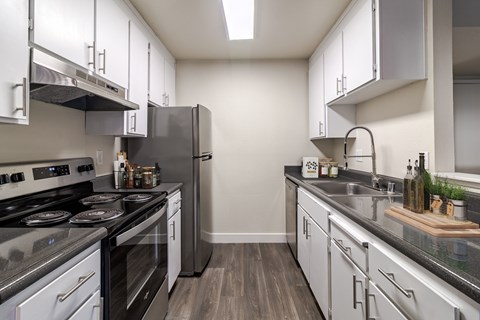 A modern kitchen with stainless steel appliances and white cabinets.
