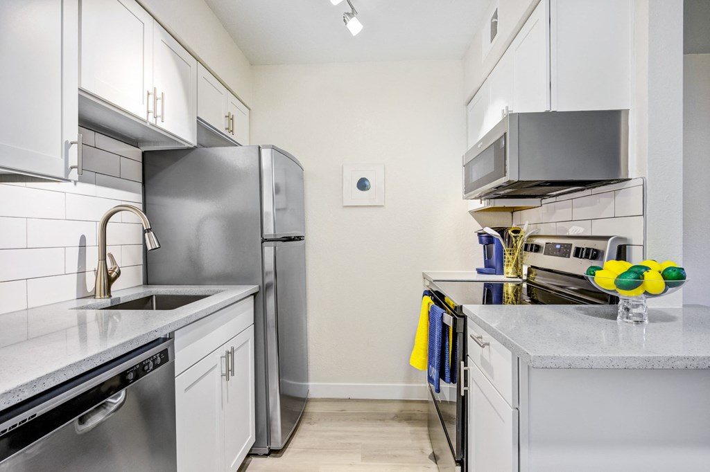 a kitchen with white cabinets and stainless steel appliances