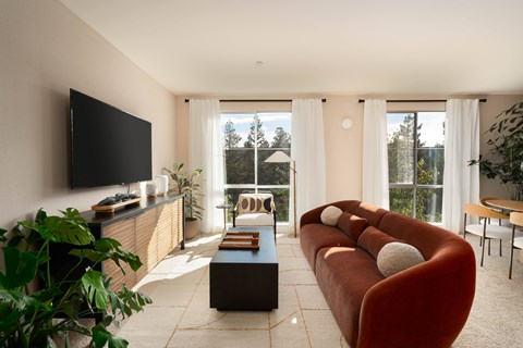 A living room with a red couch and a flat screen TV.