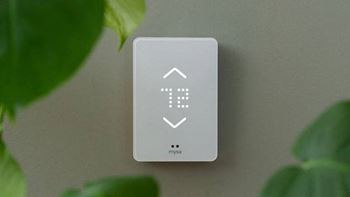 a white indirect thermostat sitting on a wall next to a green plant at Ion Town Center, Shoreline, WA