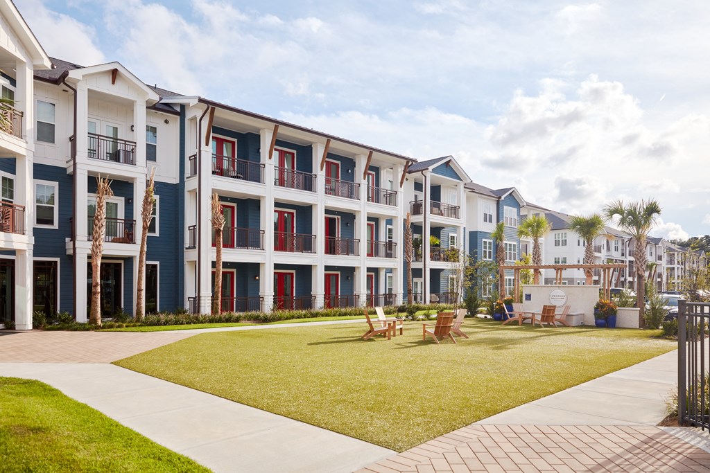 Exterior courtyard area with green space and a fire pit
