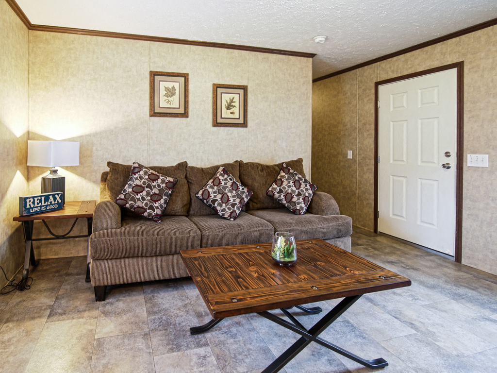 A living room with a couch, a coffee table, and a lamp.