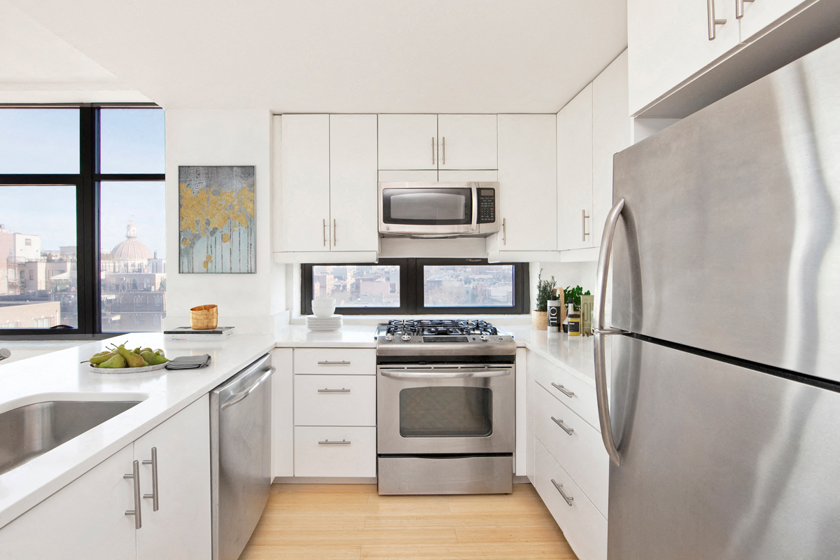 A modern kitchen with stainless steel appliances and white cabinets.