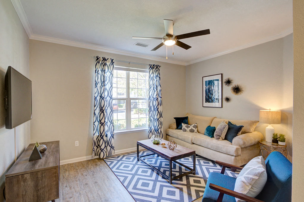 a living room with a couch and a ceiling fan