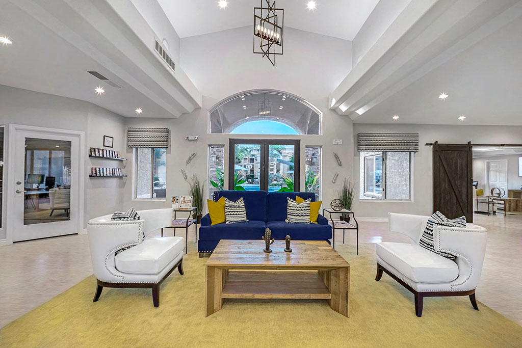 a living room with a blue couch and two white chairs
