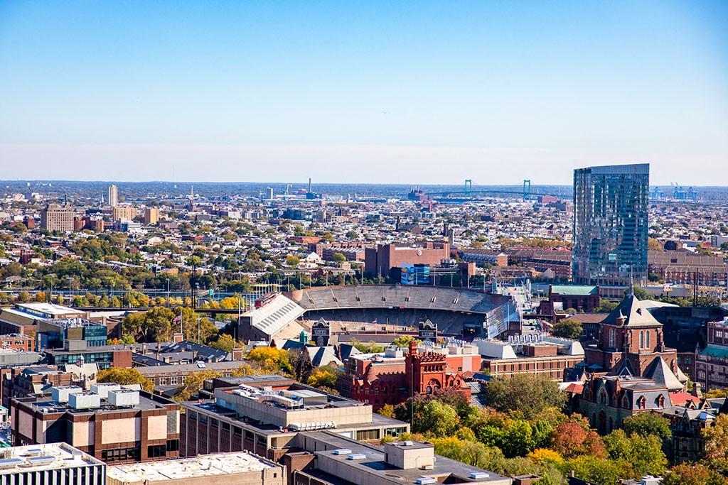 an aerial view of a city with a stadium and a tall building