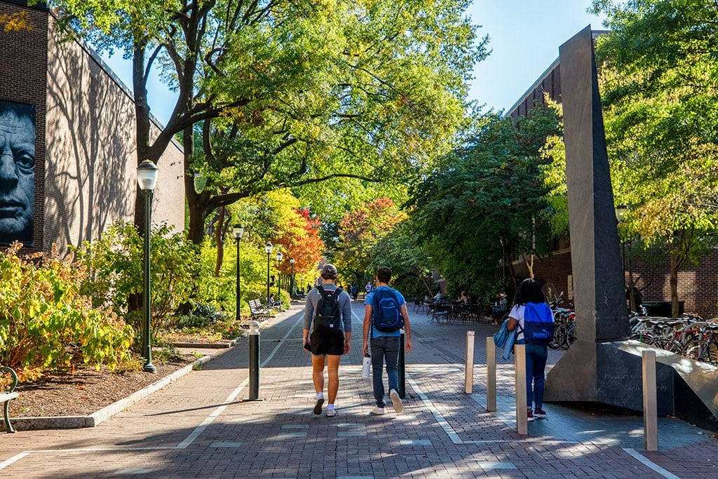a group of people walking down a sidewalk in front of a building