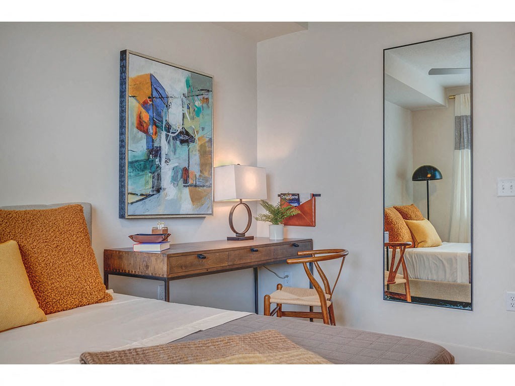 a bedroom with a bed and a desk with a mirror